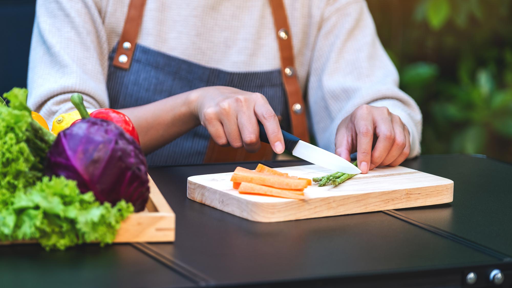 Instructor demonstrating knife skills over wooden board